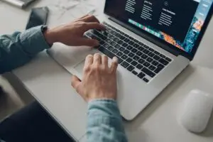 person wearing long-sleeve top working on laptop