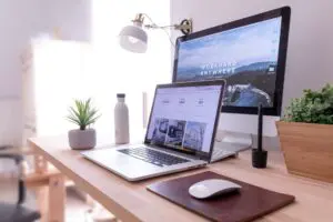 MacBook Pro on table beside white iMac and Magic Mouse