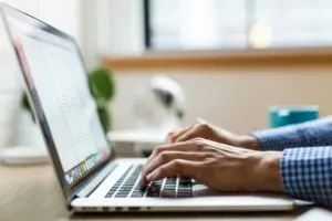 person typing on silver Macbook